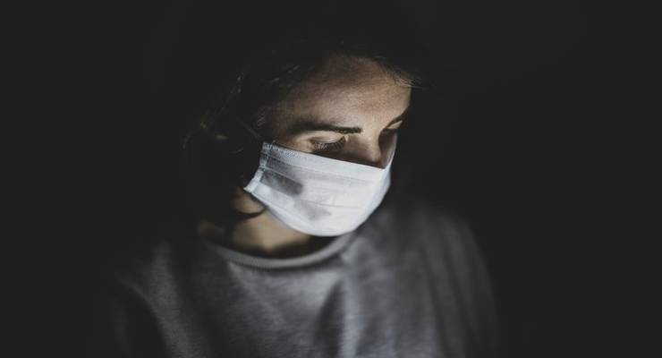woman-wearing-surgical-mask-looking-at-pjone