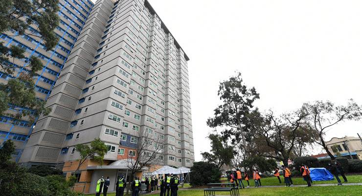public housing tower with police standing out front