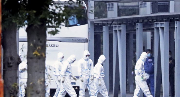 People wearing masks and protective suits in Wuhan in February 2020 (Image: AP)