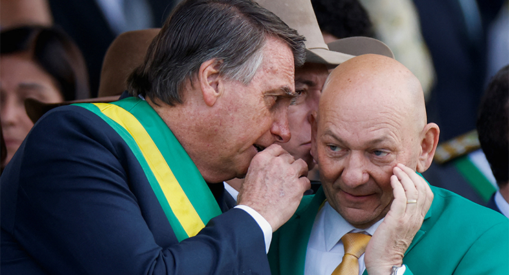 Brazil's President Jair Bolsonaro speaks with Brazilian businessman Luciano Hang (Image: AAP/Reuters/Adriano Machado)