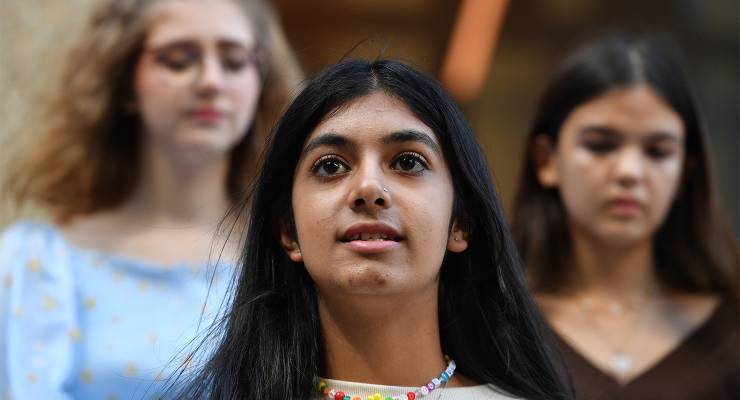 Anjali Sharma (centre) joined by Ava Princi (left) and Izzy Raj-Seppings (right) outside the NSW Federal Court, 2022 (Image: AAP/Dean Lewins)