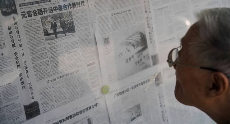 A man reads a newspaper in Beijing, China (Image: EPA/Wu Hao)