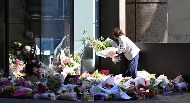 A woman lays flowers at the memorial of Lilie James (Image: AAP/Dean Lewins)