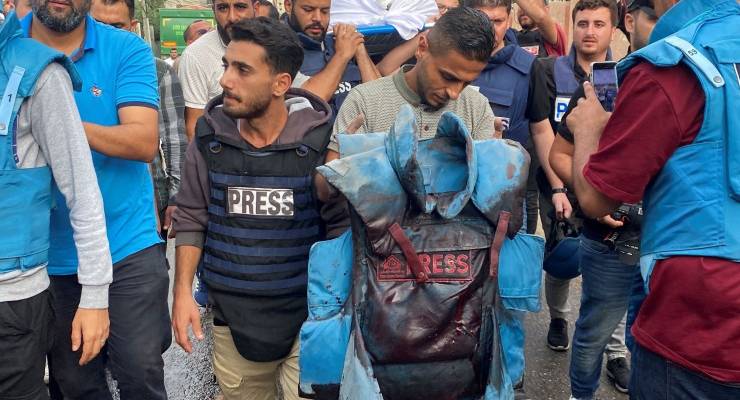A colleague carries a blood-stained flak jacket belonging to Palestinian journalist Mohammed Soboh (Image: AAP/Reuters)