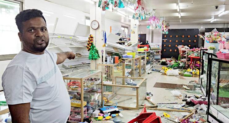 A man points to shop damage after looting in Port Moresby (Image: AP/Gorethy Kenneth)